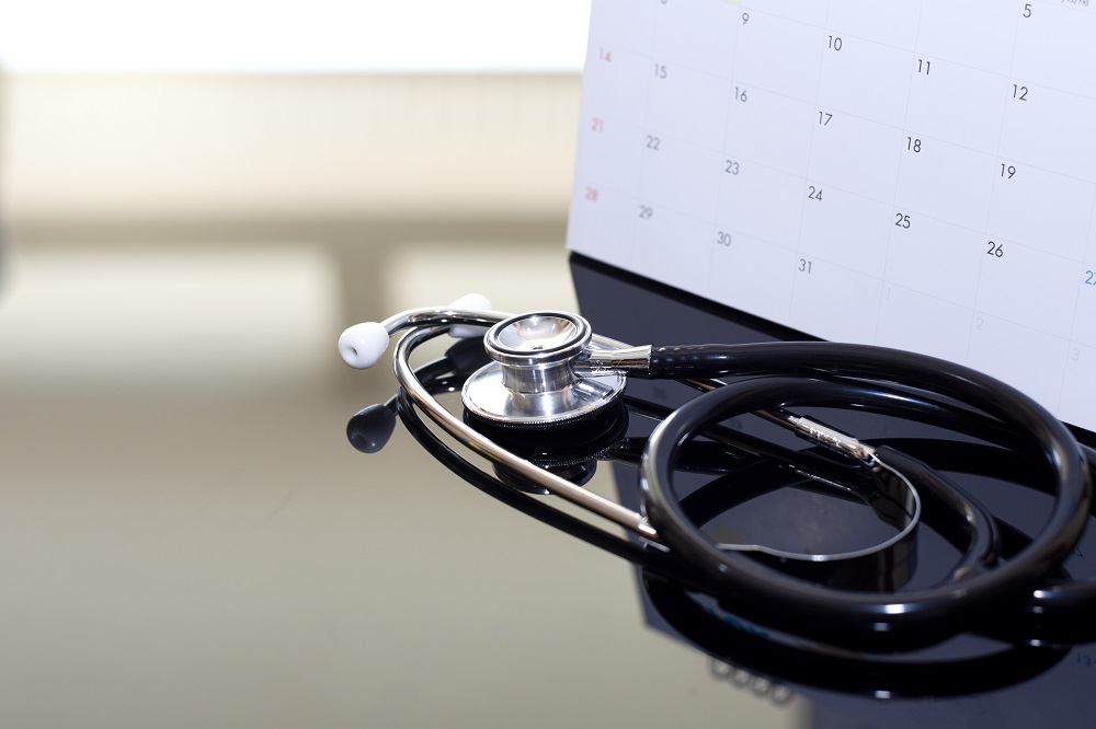 Medical stethoscope and calendar on the dark table. Yearly health check up, doctor appointment, fallow up, annual medical checkup concept. | Virtual Assistant For Doctors