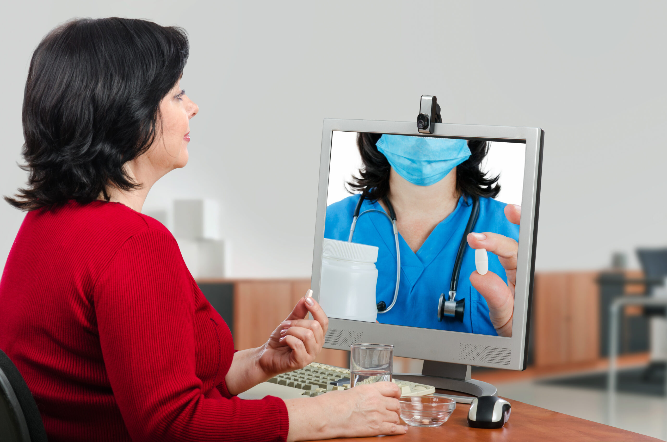 A businesswoman looks at a telemedicine doctor's instructions about the possible side effects of the pills taken.