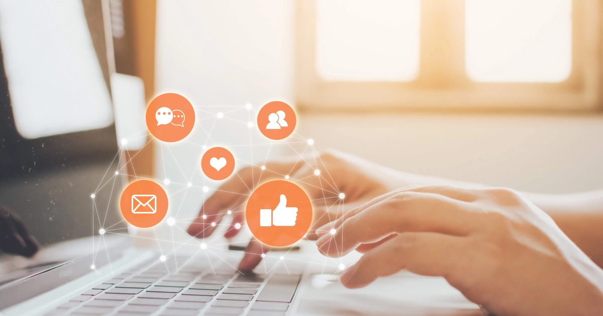 Digital Marketing Assistant typing on a laptop with digital social media icons overlayed, set in a bright, sunlit office or home environment.